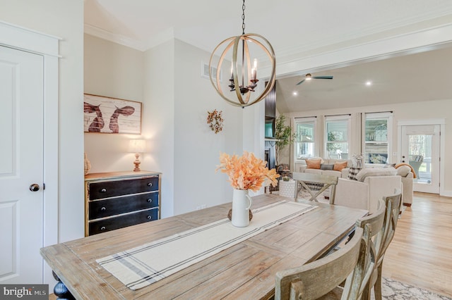 dining room with ceiling fan with notable chandelier, light hardwood / wood-style flooring, and ornamental molding