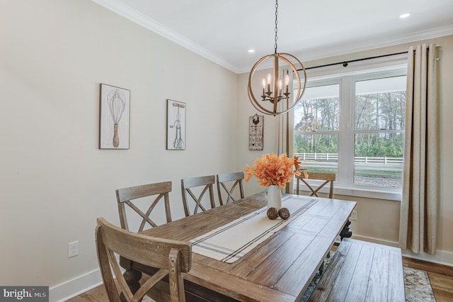 dining space with crown molding, hardwood / wood-style floors, and a chandelier