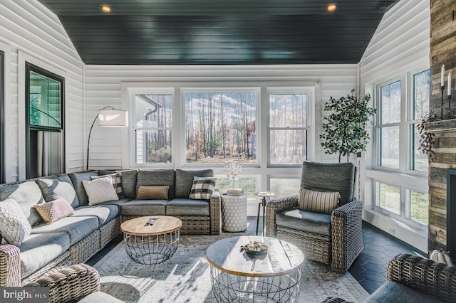 sunroom / solarium with vaulted ceiling, plenty of natural light, and wooden ceiling