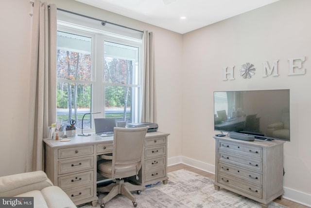 home office with light hardwood / wood-style floors