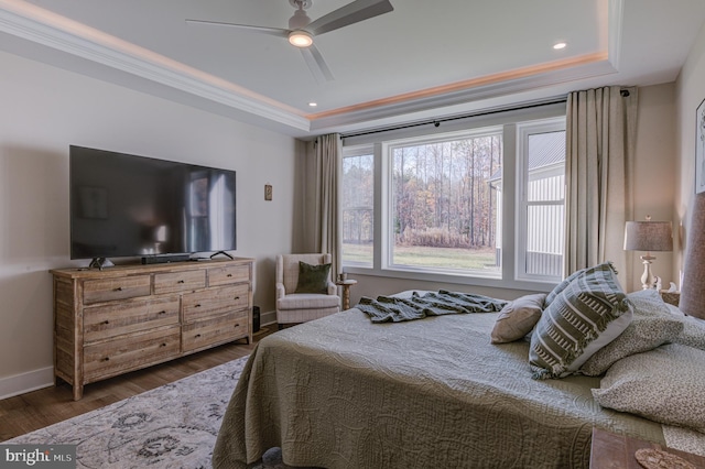 bedroom with a raised ceiling, ceiling fan, dark hardwood / wood-style flooring, and ornamental molding