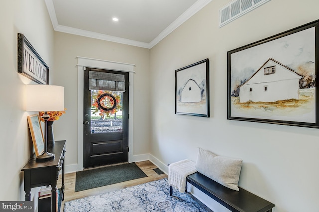 foyer entrance with hardwood / wood-style flooring and ornamental molding