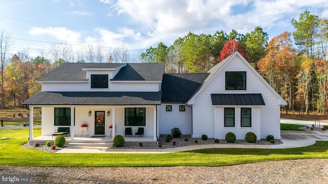 modern farmhouse style home with a front lawn and a porch