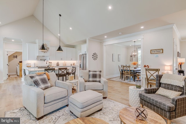 living room featuring crown molding, light hardwood / wood-style flooring, and sink