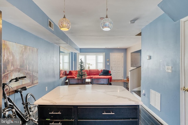 kitchen featuring light stone countertops and hanging light fixtures