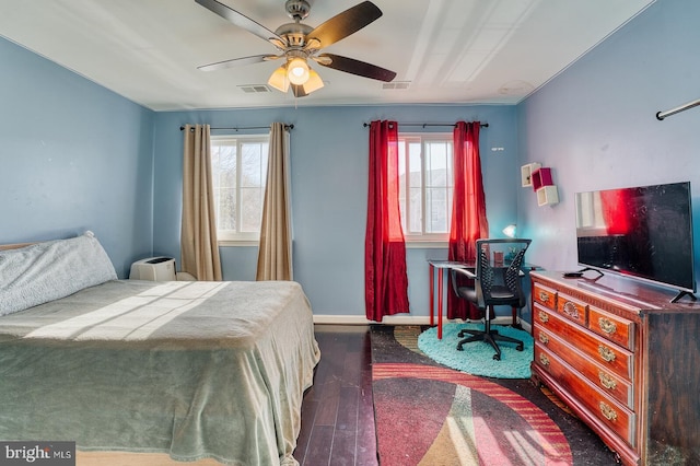 bedroom featuring dark hardwood / wood-style floors, ceiling fan, and multiple windows