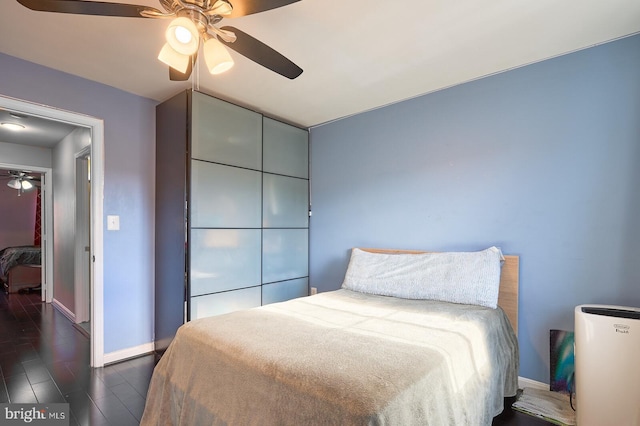 bedroom featuring ceiling fan and dark wood-type flooring