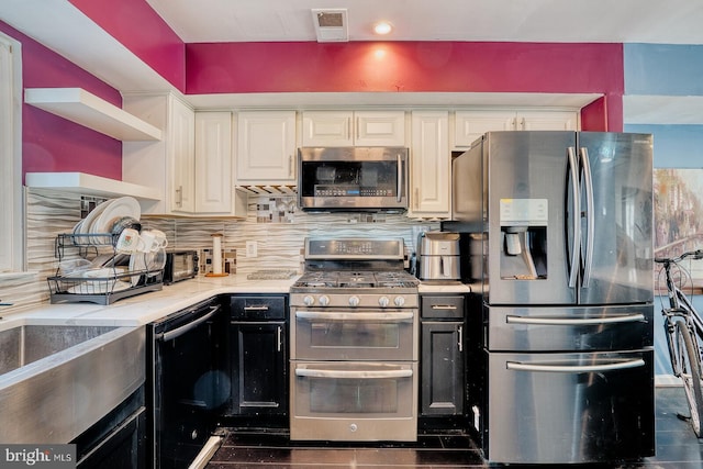 kitchen with light stone counters, white cabinetry, appliances with stainless steel finishes, and tasteful backsplash