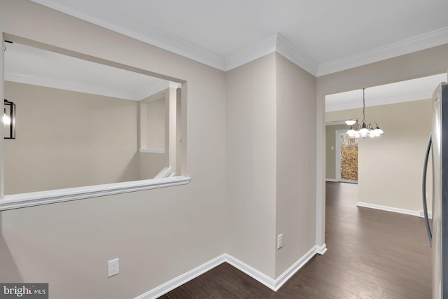 hall with a notable chandelier, dark hardwood / wood-style floors, and crown molding