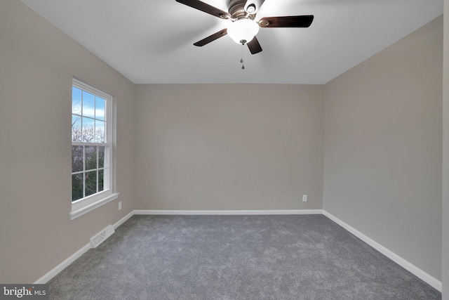 empty room with dark colored carpet and ceiling fan