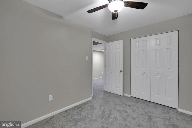 unfurnished bedroom featuring ceiling fan, a closet, and light carpet