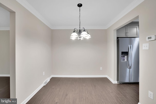 unfurnished dining area with a notable chandelier, crown molding, and dark wood-type flooring