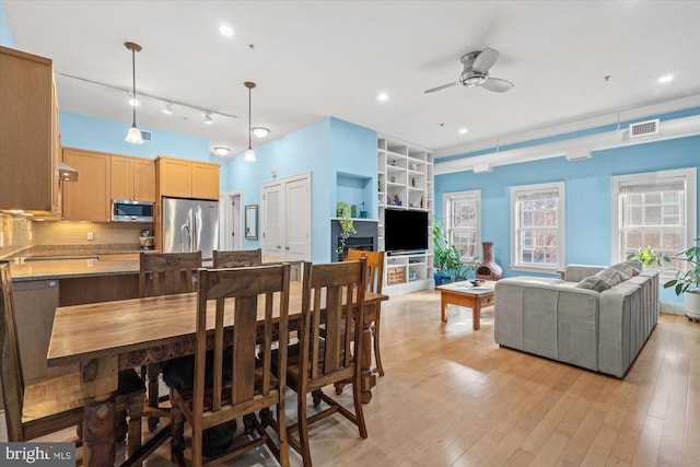 dining room featuring ceiling fan, light wood-type flooring, and track lighting