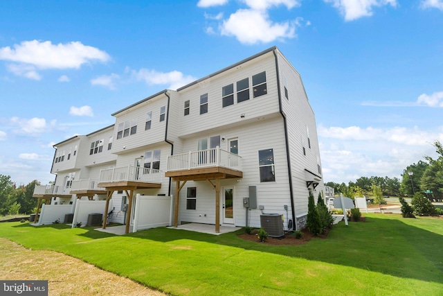 rear view of house featuring central AC unit, a yard, and a patio