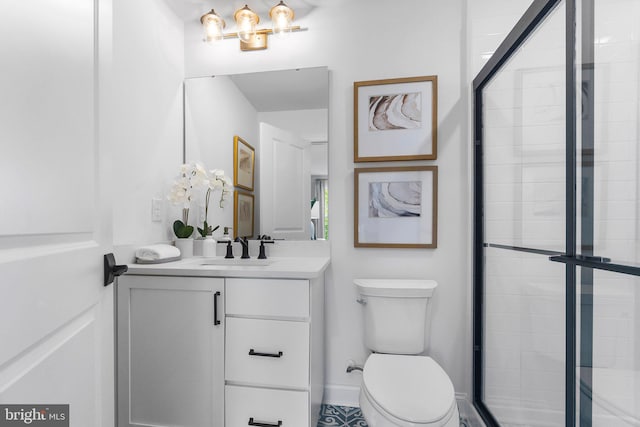 bathroom with vanity, toilet, and a shower with shower door