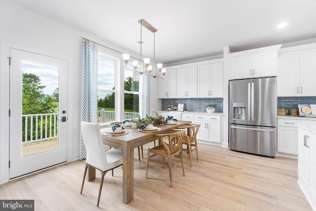 dining area featuring light hardwood / wood-style flooring and a notable chandelier