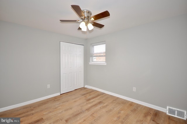 unfurnished bedroom featuring ceiling fan, a closet, and light hardwood / wood-style flooring