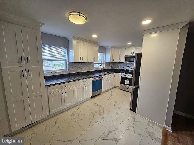 kitchen featuring tasteful backsplash, white cabinetry, sink, and stainless steel appliances