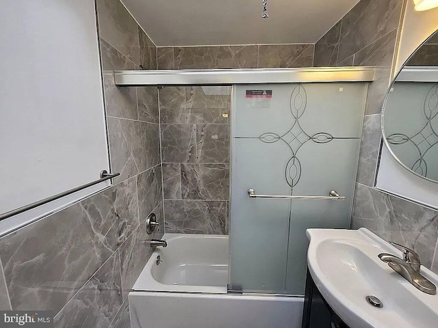 bathroom featuring vanity, enclosed tub / shower combo, and tile walls