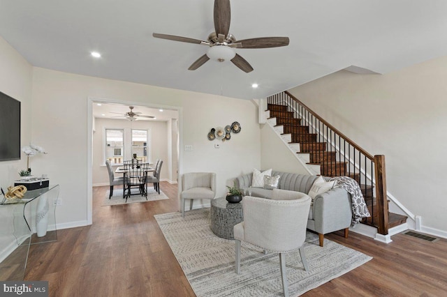 living room featuring ceiling fan and dark hardwood / wood-style flooring