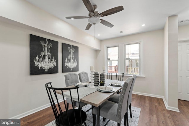 dining room with hardwood / wood-style floors and ceiling fan with notable chandelier