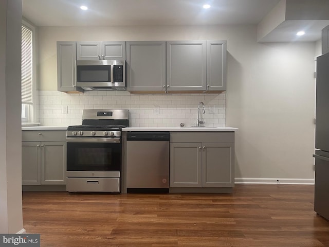 kitchen with gray cabinets, sink, appliances with stainless steel finishes, and dark wood-type flooring