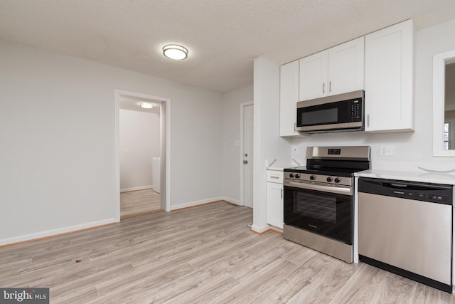 117 N Virginia Ave, Richmond, VA 23223 - kitchen with stainless steel appliances, light wood-style floors, white cabinets, baseboards, and a textured ceiling