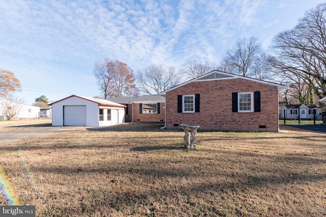 single story home with a garage, an outbuilding, and a front lawn