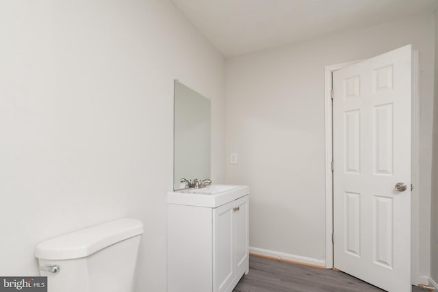 bathroom featuring vanity, hardwood / wood-style flooring, and toilet