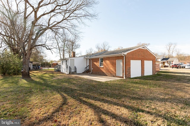 exterior space with a patio, a garage, and a lawn