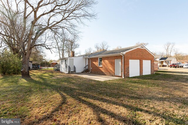 117 N Virginia Ave, Richmond, VA 23223 - back of property with brick siding, a yard, a chimney, and a patio