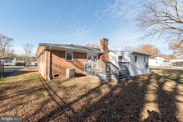 117 N Virginia Ave, Richmond, VA 23223 - rear view of house featuring brick siding, a wooden deck, central air condition unit, a chimney, and a lawn