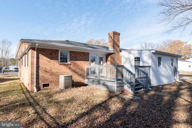 rear view of house with central AC unit, a lawn, and a wooden deck