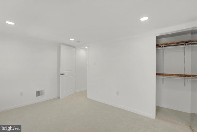 unfurnished bedroom featuring a closet and light colored carpet