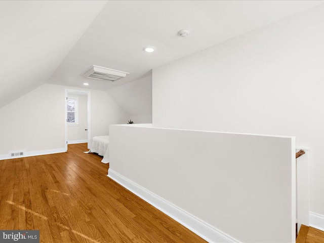 bonus room with hardwood / wood-style flooring and vaulted ceiling