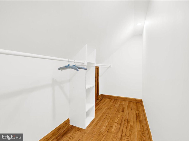 spacious closet with wood-type flooring and vaulted ceiling