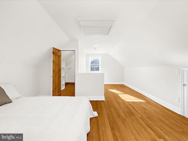 unfurnished bedroom featuring hardwood / wood-style floors and vaulted ceiling