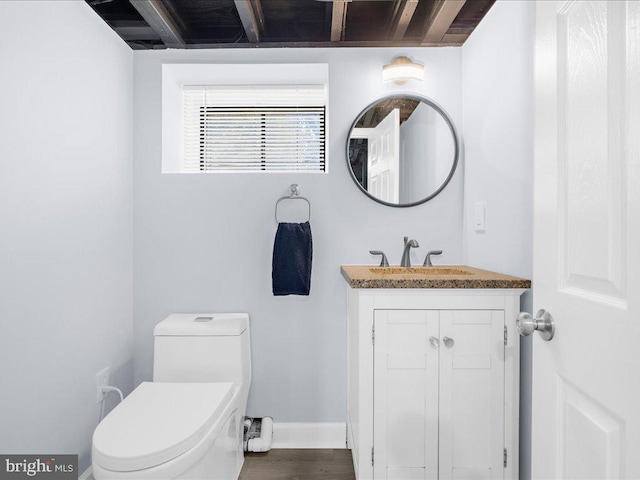 bathroom with hardwood / wood-style floors, vanity, and toilet