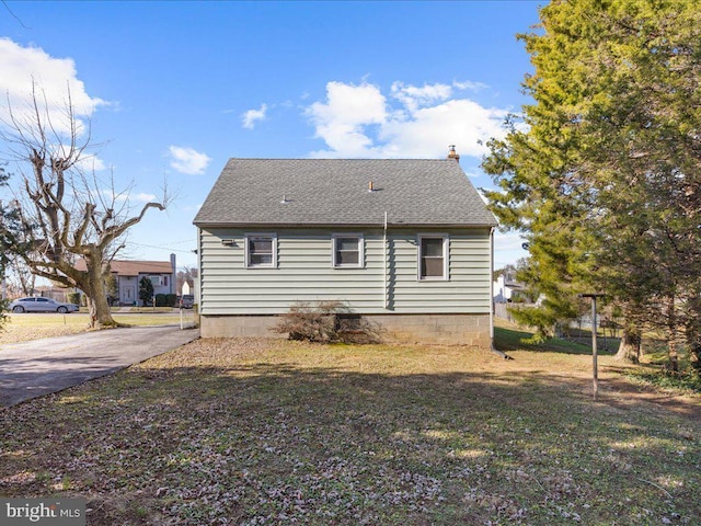 rear view of property with a lawn