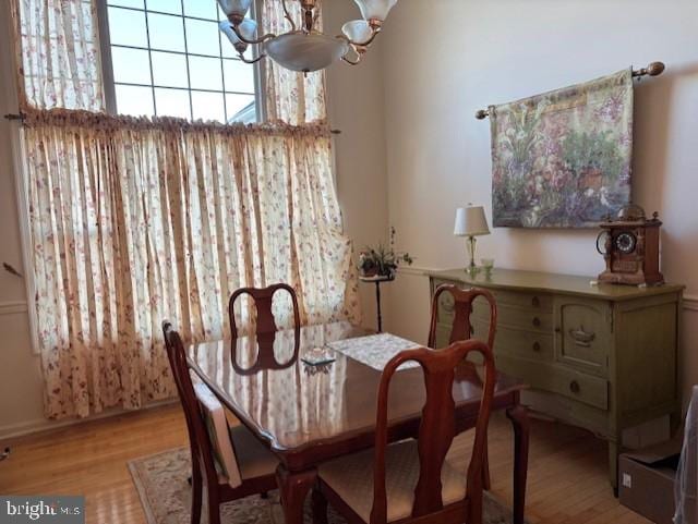 dining area featuring light hardwood / wood-style flooring and a chandelier