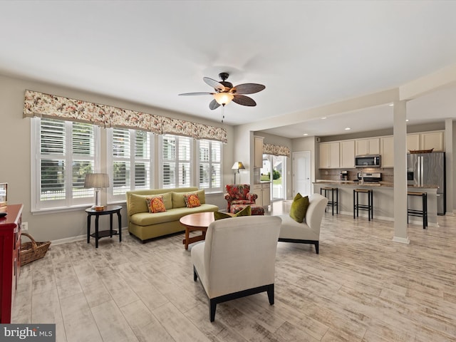 living room with light wood-type flooring and ceiling fan