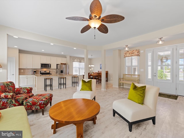 living room with light hardwood / wood-style flooring and ceiling fan