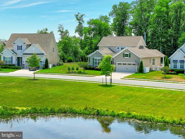 view of front of house with a front yard, a water view, and a garage