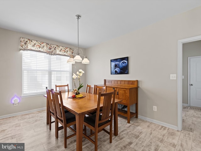 dining space featuring a chandelier and light wood-type flooring