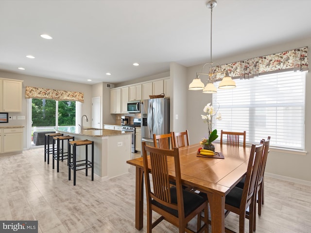 dining area featuring light wood-type flooring and an inviting chandelier