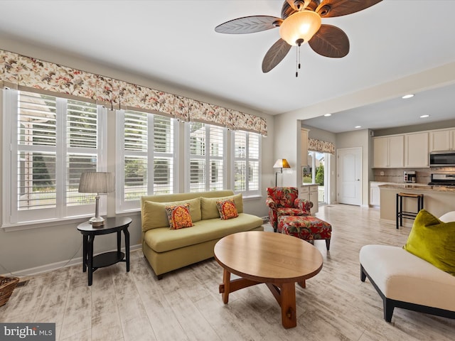 living room with light hardwood / wood-style flooring, plenty of natural light, and ceiling fan