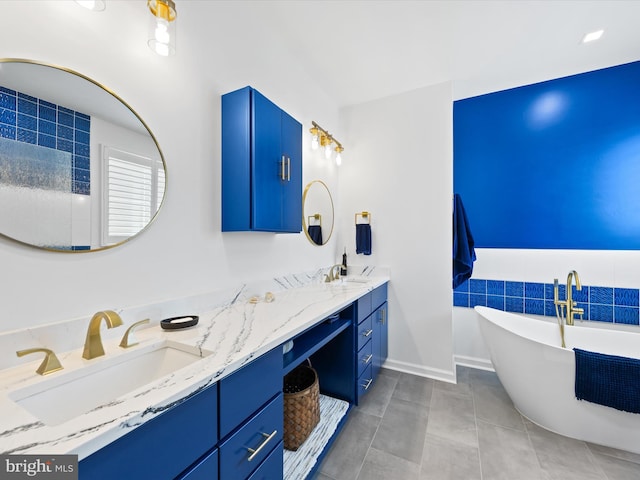 bathroom with tile patterned flooring, a washtub, and vanity