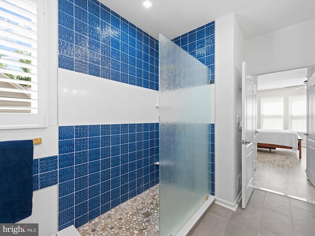 bathroom featuring tile patterned flooring, tile walls, and a healthy amount of sunlight