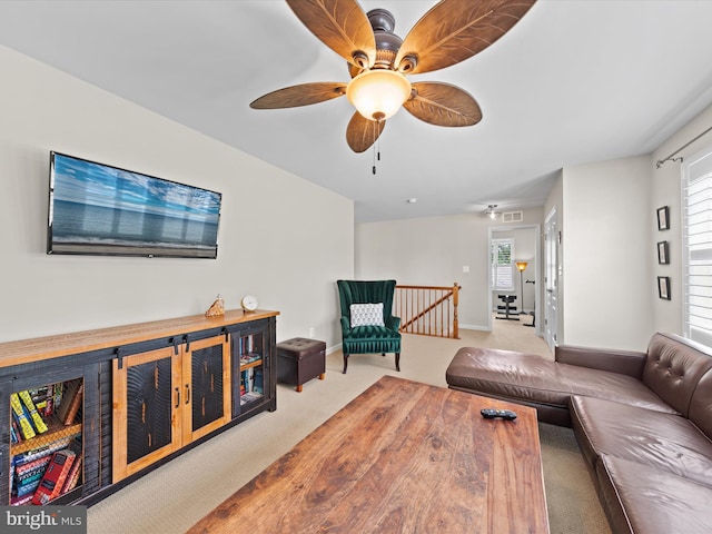 carpeted living room with ceiling fan