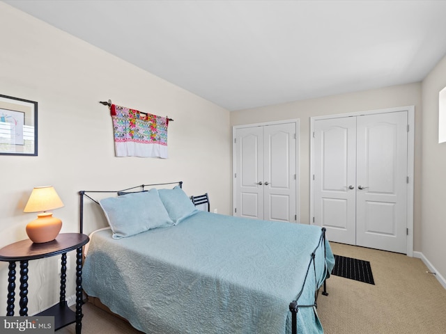 bedroom with carpet flooring and two closets